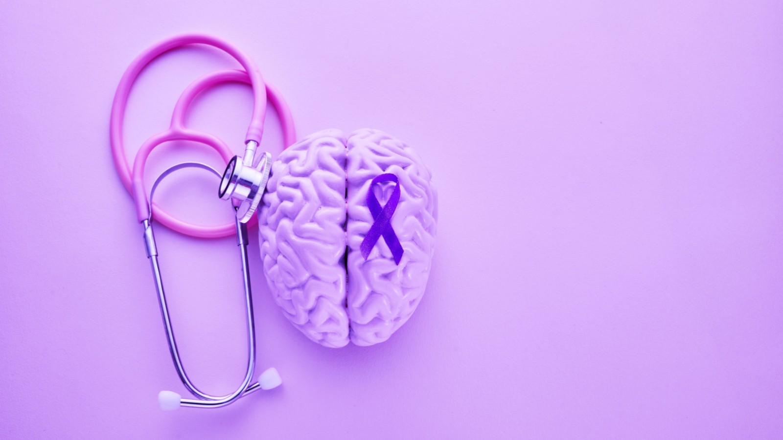 Purple stethoscope and purple brain in a purple background