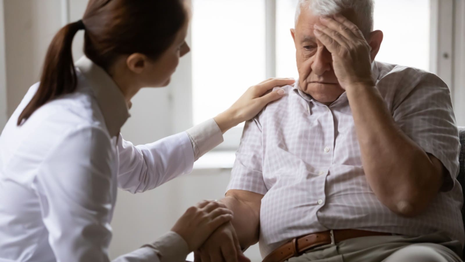 Old man complaining to a female doctor for headache