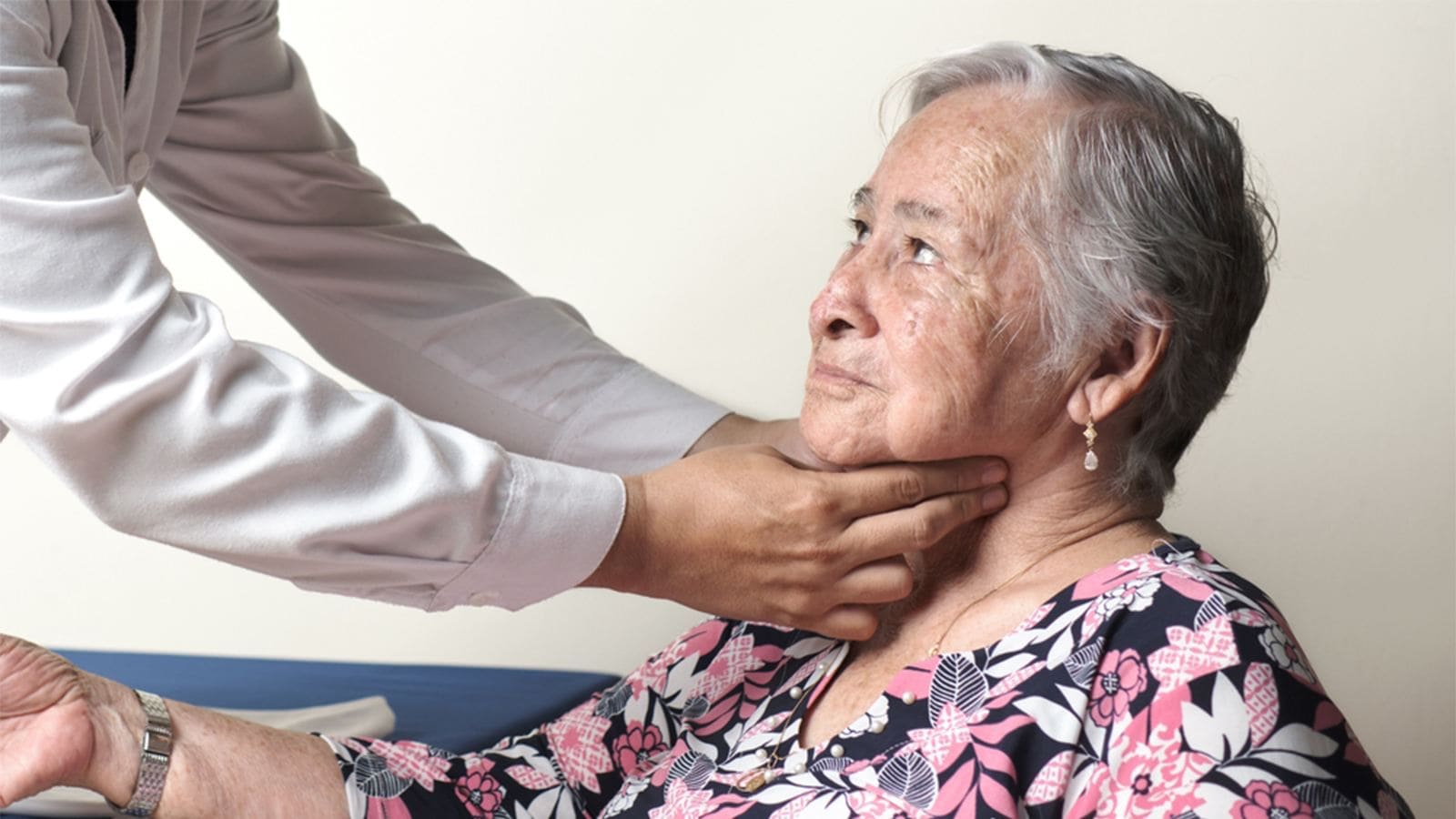 Doctor checking the pulse of the carotid artery of an elderly woman