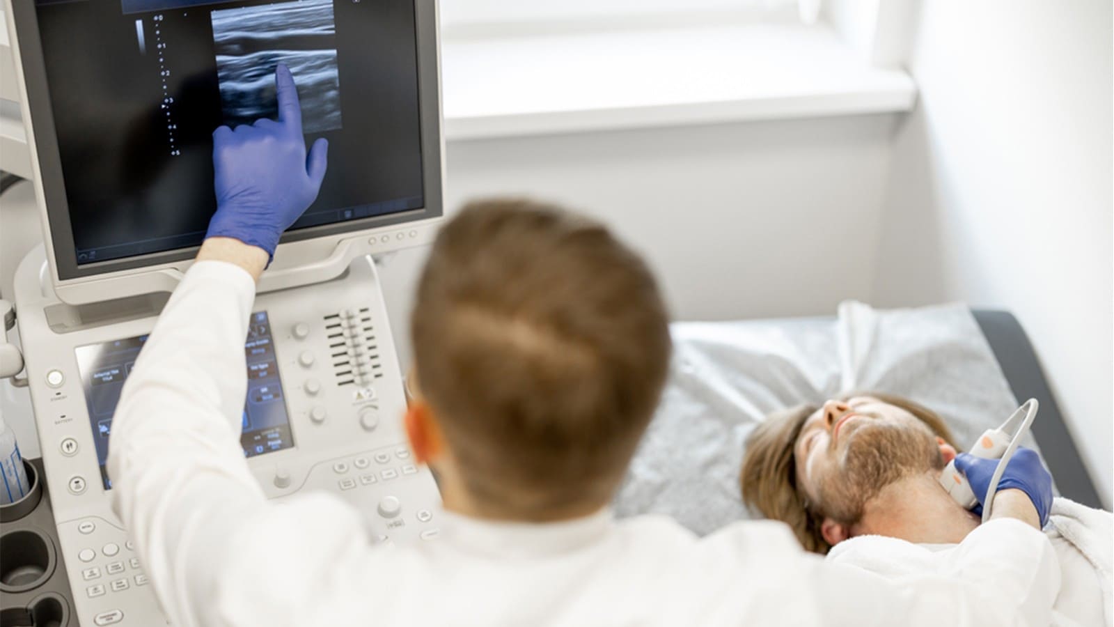 Doctor pointing on the screen during a carotid ultrasound procedure