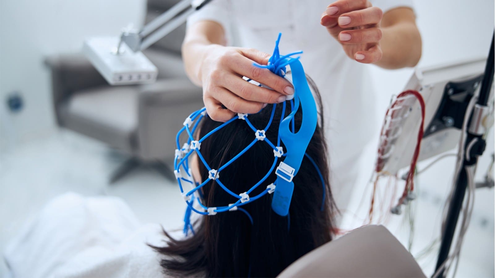 Female medical specialist removing silicone cap after performing an EEG